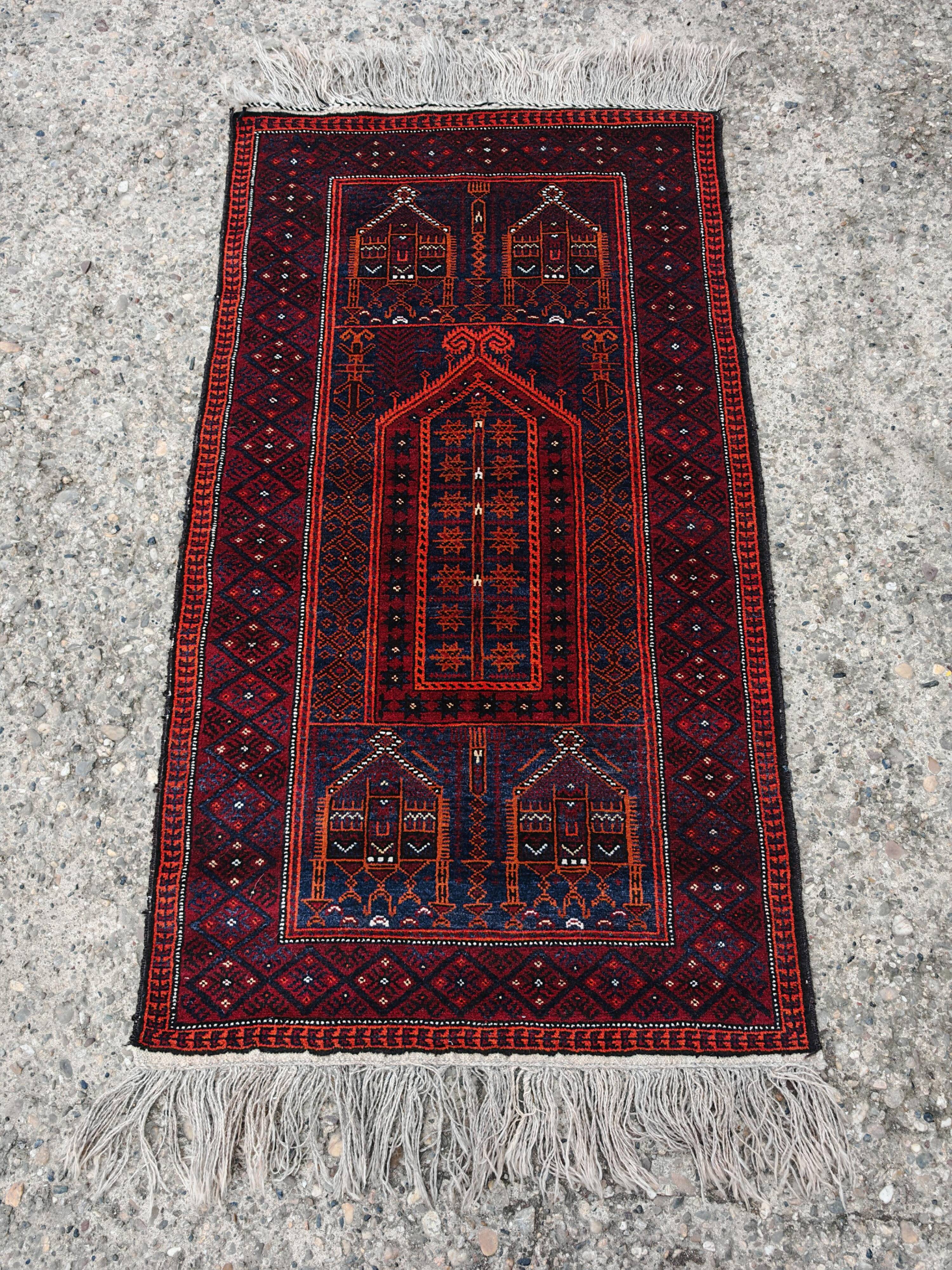 Vintage hand-knotted Persian Baluch prayer rug from the 1940s.