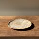 Small oval beige petrified wood dish or tray with speckled edges.