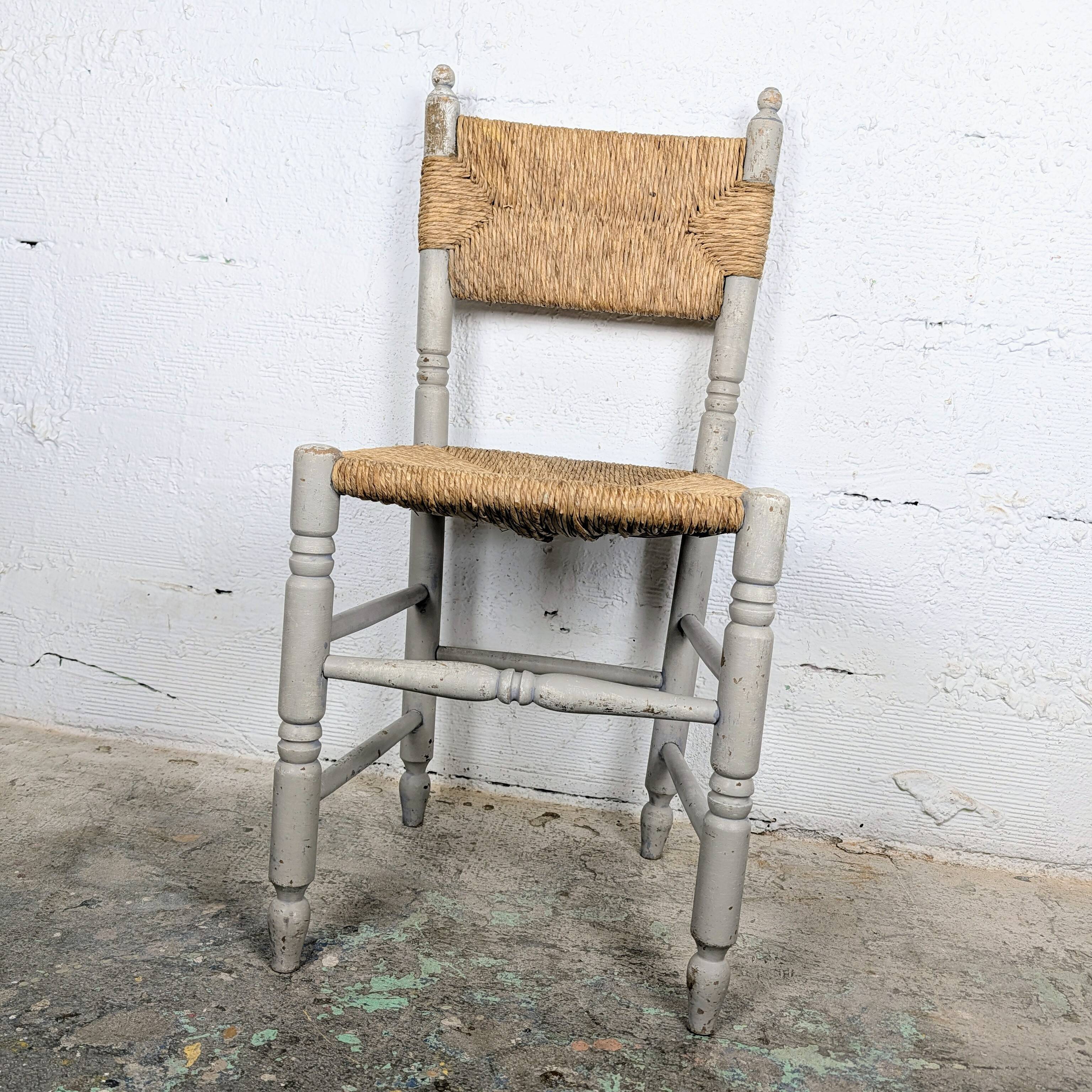 Rustic chair made of turned wood and straw.