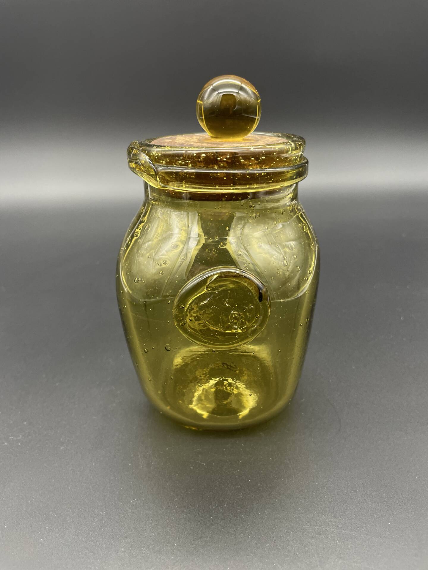 Yellow bubbled glass apothecary jar with cork lid.