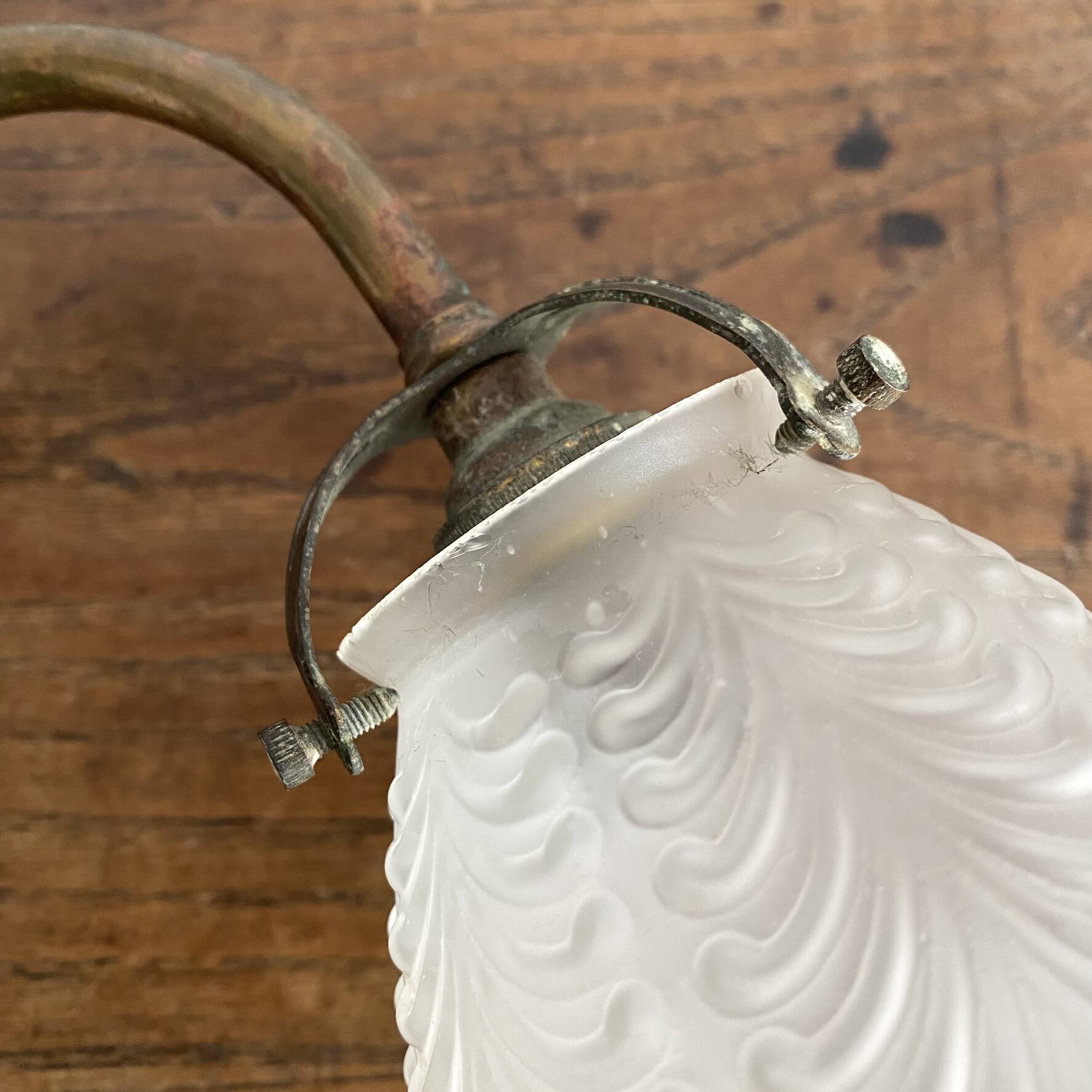 Antique swan neck wall light in brass and porcelain with a glass shade.