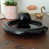 Vintage black ceramic candle holder on a bowl