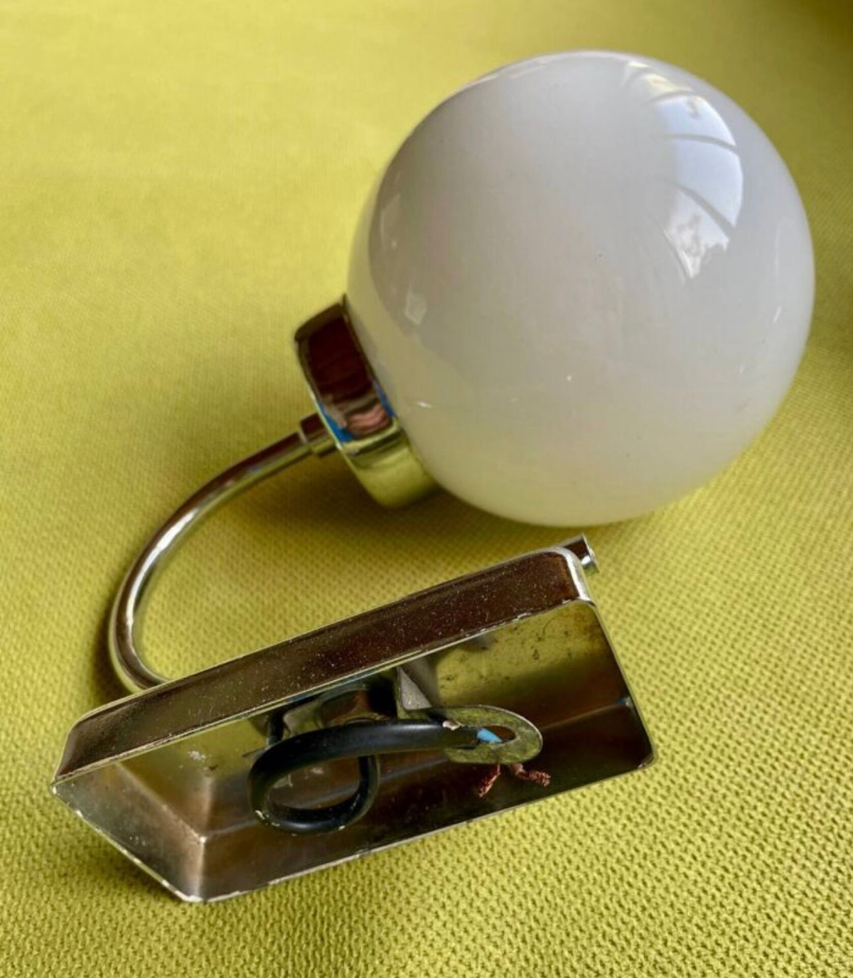 Pair of chrome metal wall lights with white glass globe.
