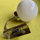 Pair of chrome metal wall lights with white glass globe.