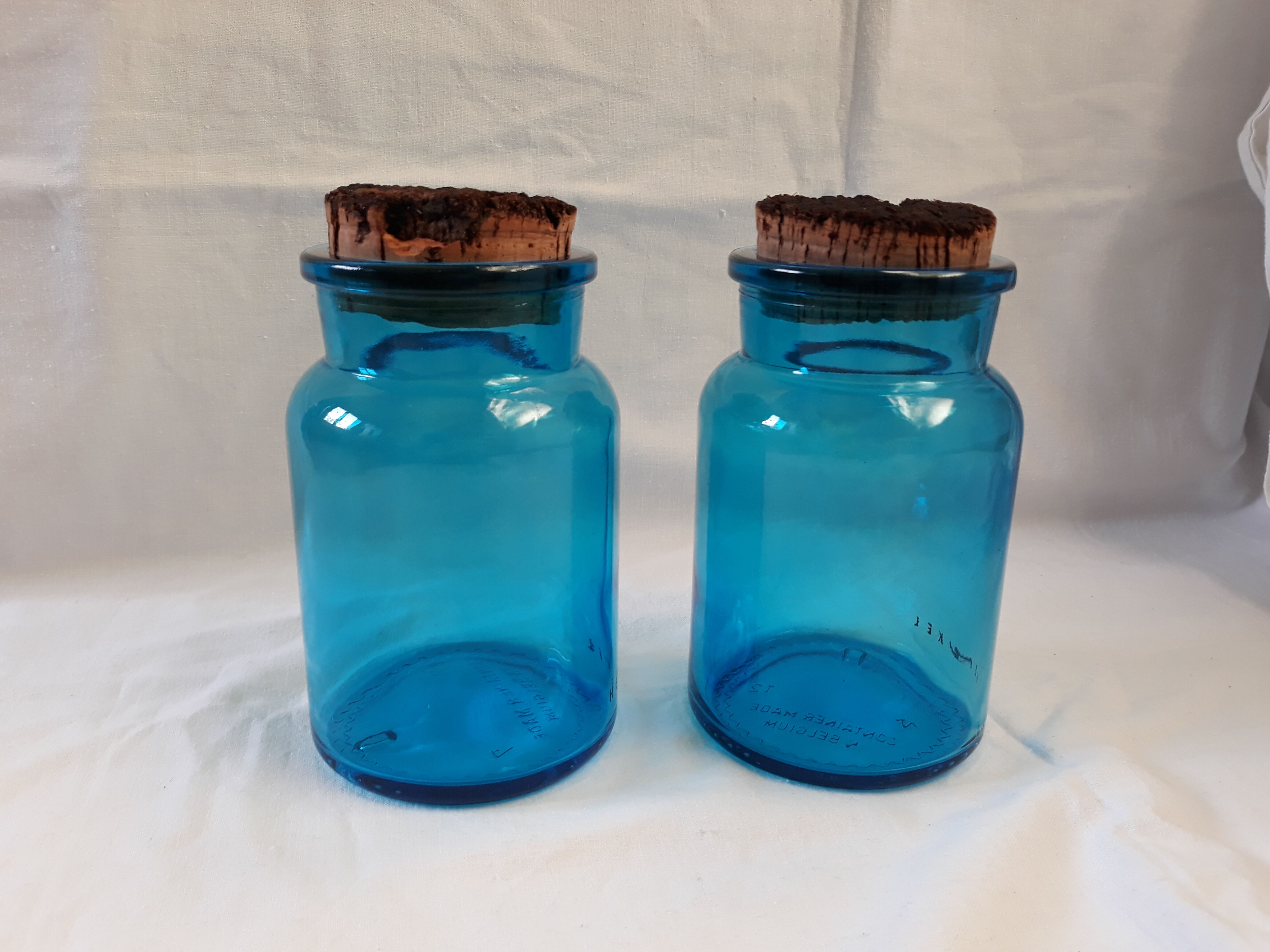 pair of apothecary vials in blue glass jar