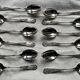 Set of 12 small silver-plated metal spoons in Art Nouveau style.