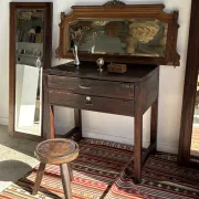 Antique mirror door (left) of a brown oak wardrobe with bevelled glass.