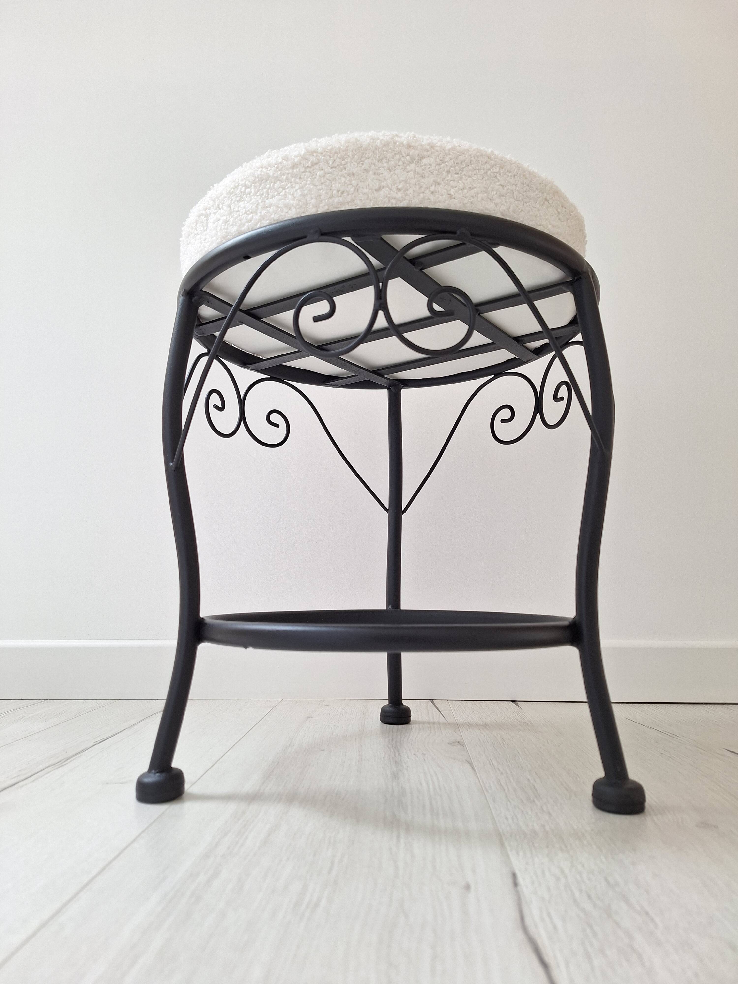 Black iron stool/pouf with its boucle fabric cushion.