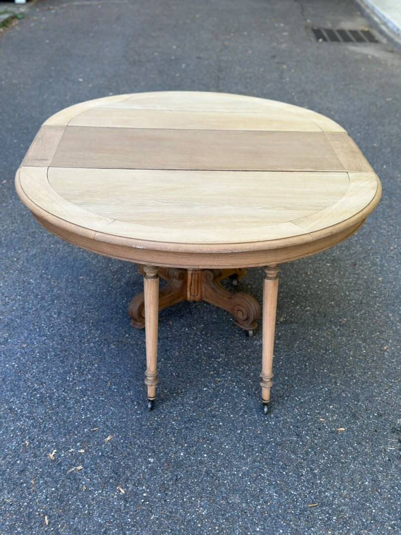 Round dining table with a central pedestal, stripped raw oak, 4 extensions, 19th century.