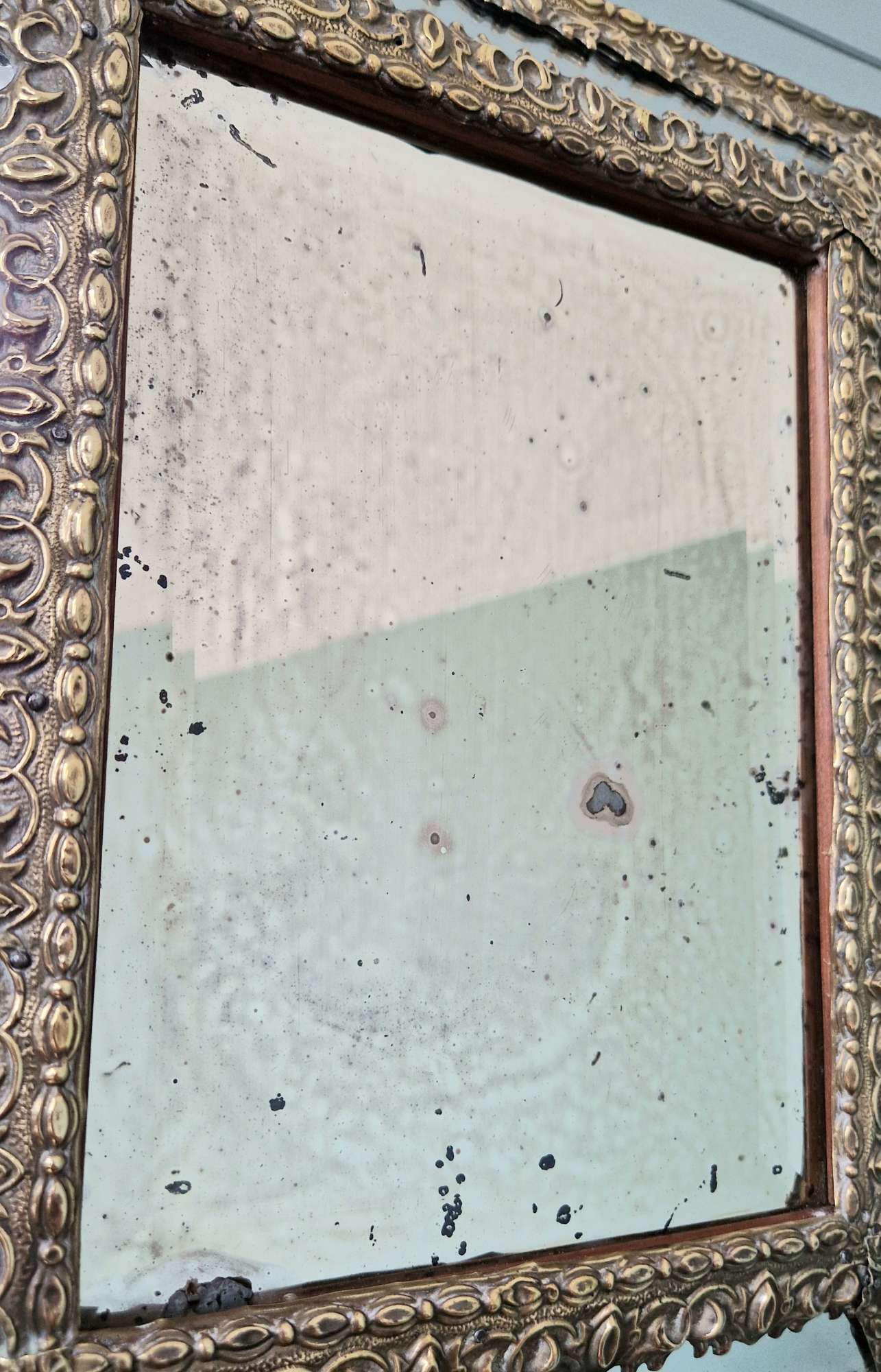 Mirror with repoussé brass frame, mercury glass, 19th century.