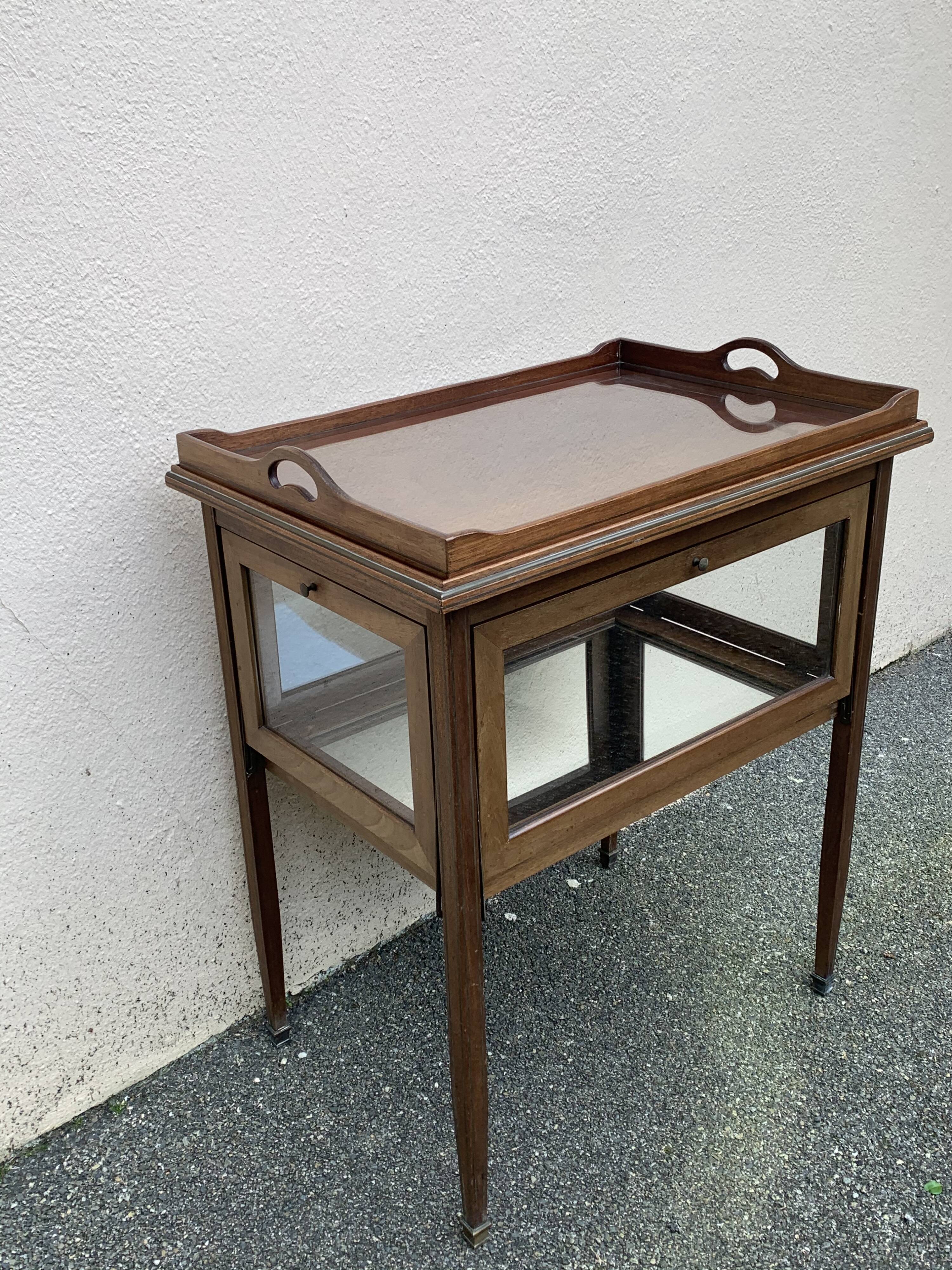 Glass-enclosed old tea table with wooden tray, bronze and brass