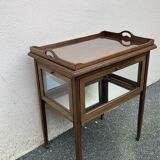Glass-enclosed old tea table with wooden tray, bronze and brass