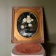 Large still life with white roses in an old gilded oval frame.