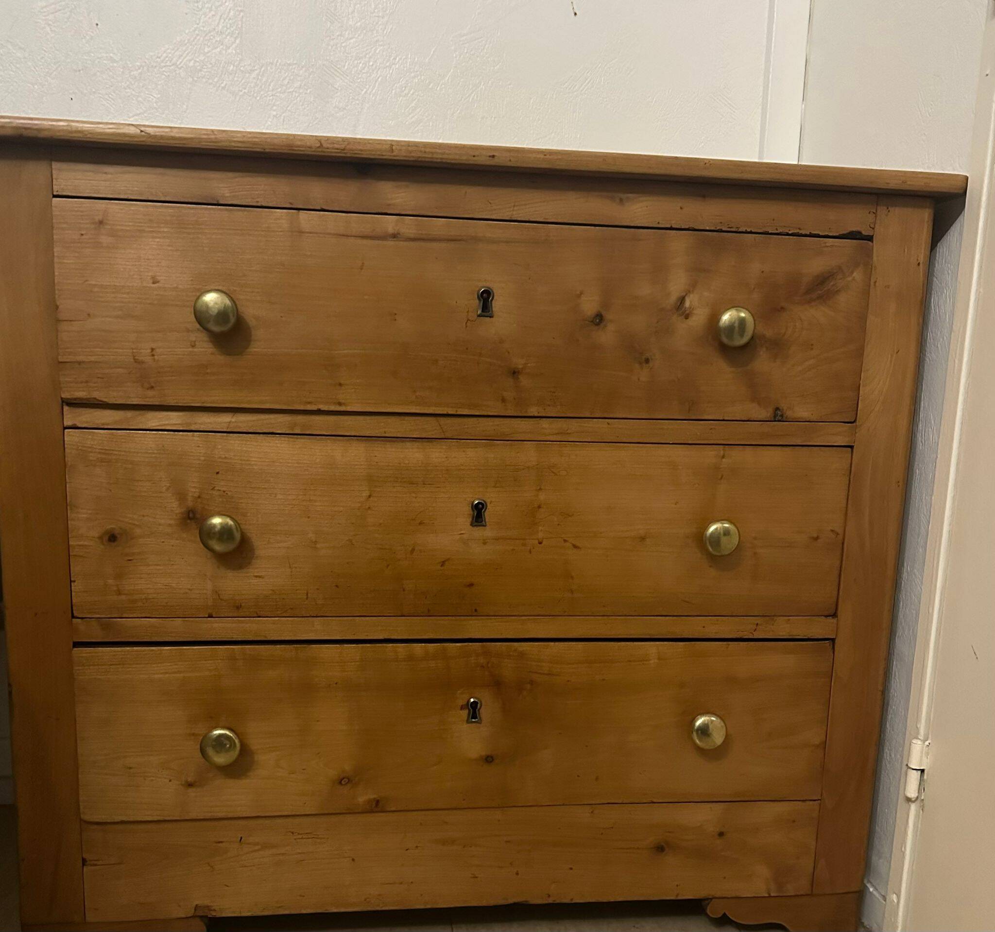 Rustic English pine chest of drawers with porcelain knobs.