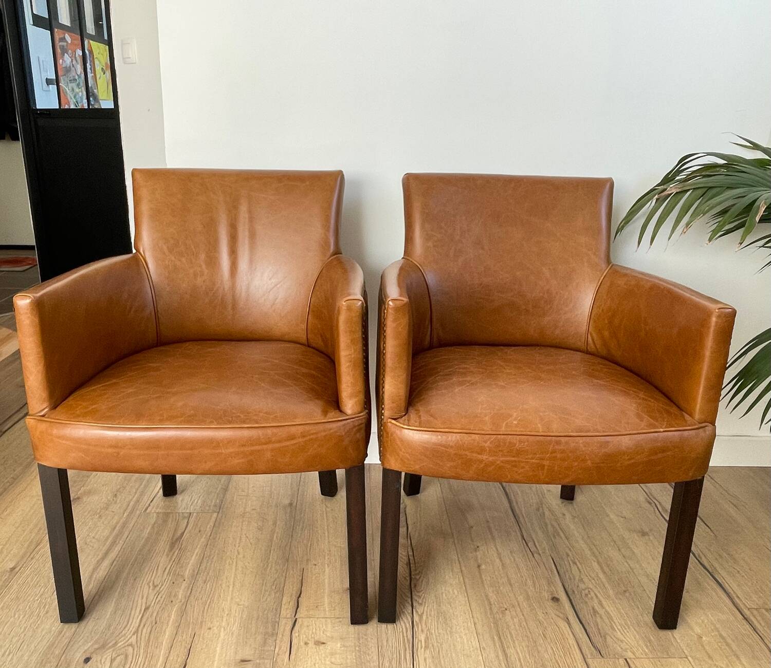Chair with armrests in aged brown cowhide leather