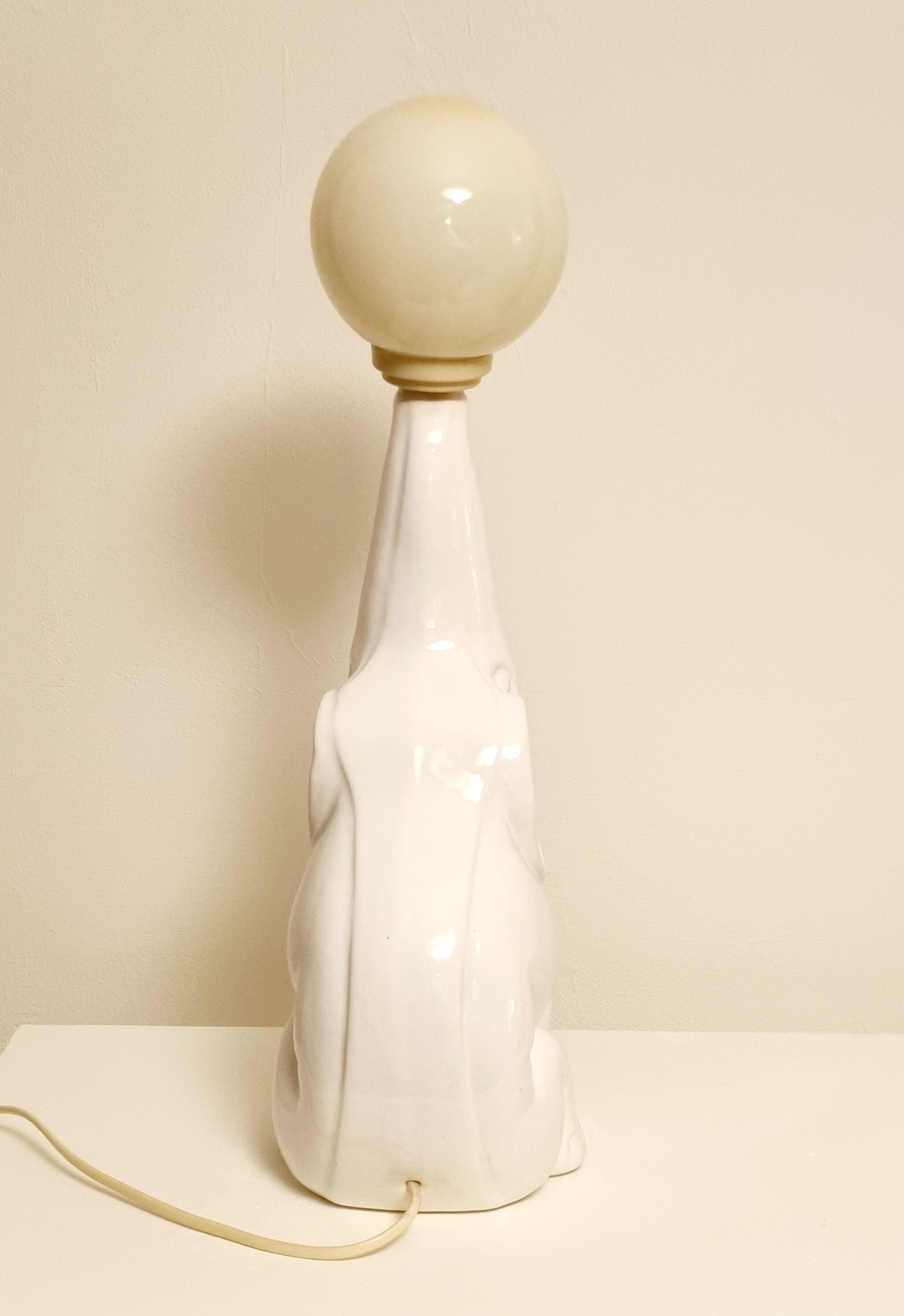 White ceramic table lamp, an elephant holding a lighted ball