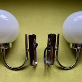 Pair of chrome metal wall lights with white glass globe.