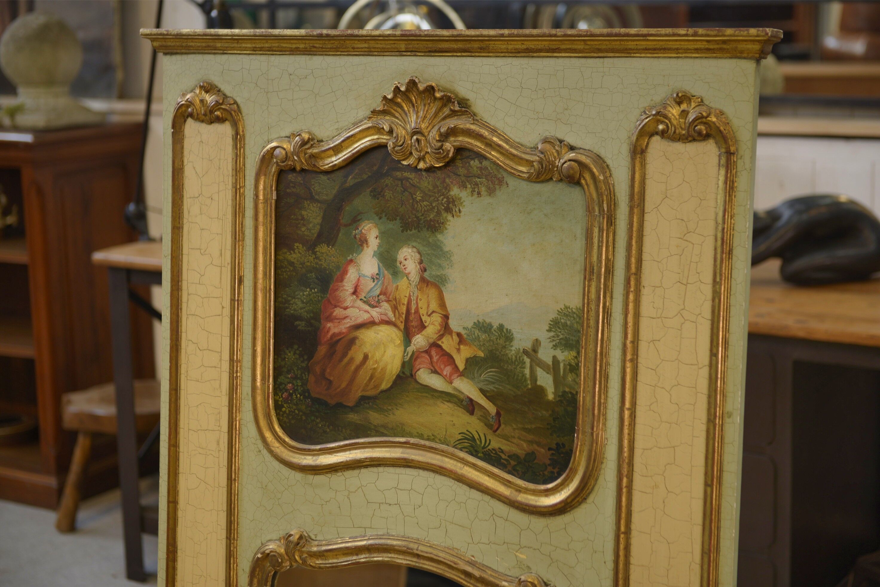 Trumeau mirror with cracked patina and oil on panel depicting a romantic scene from the 19th century.