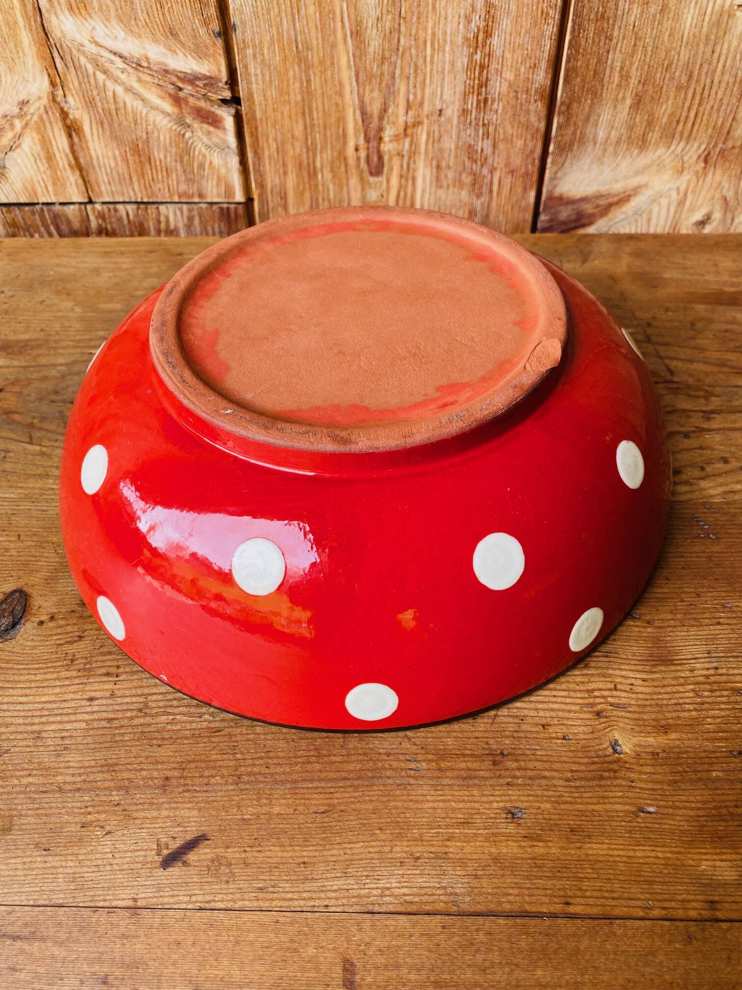 Ceramic salad bowl in red with white polka dots.