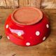 Ceramic salad bowl in red with white polka dots.