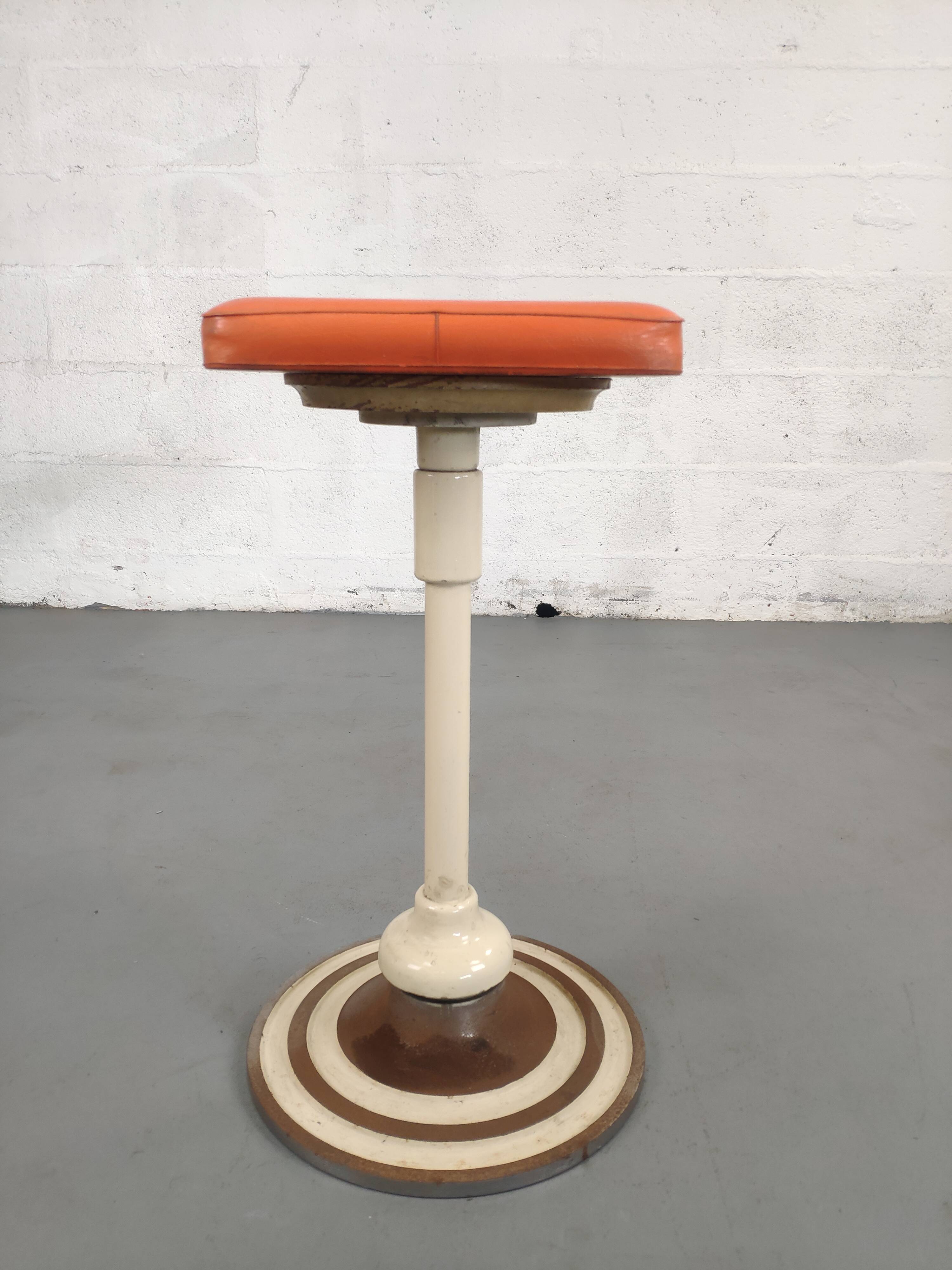 Old swivel orange sitting dentist stool