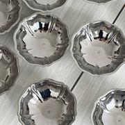 Set of 9 low bowls in shiny stainless steel.