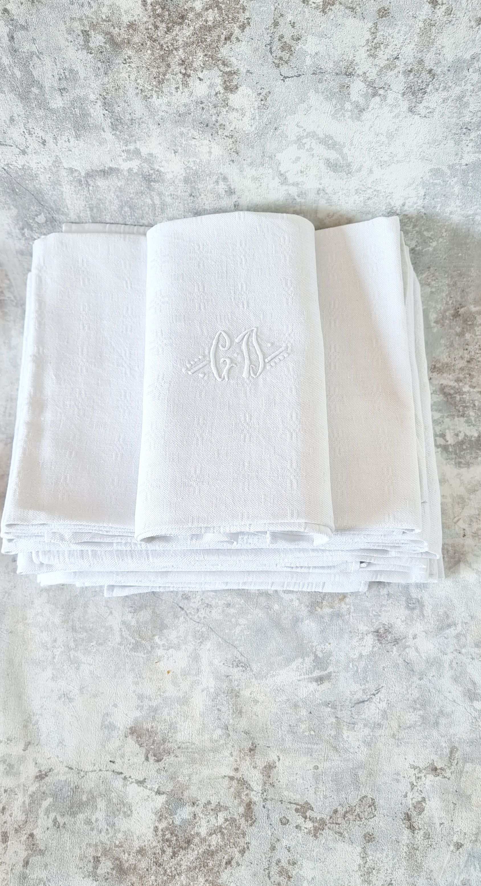 12 antique French linen towels with damask embroidery with "GB" anagrams.