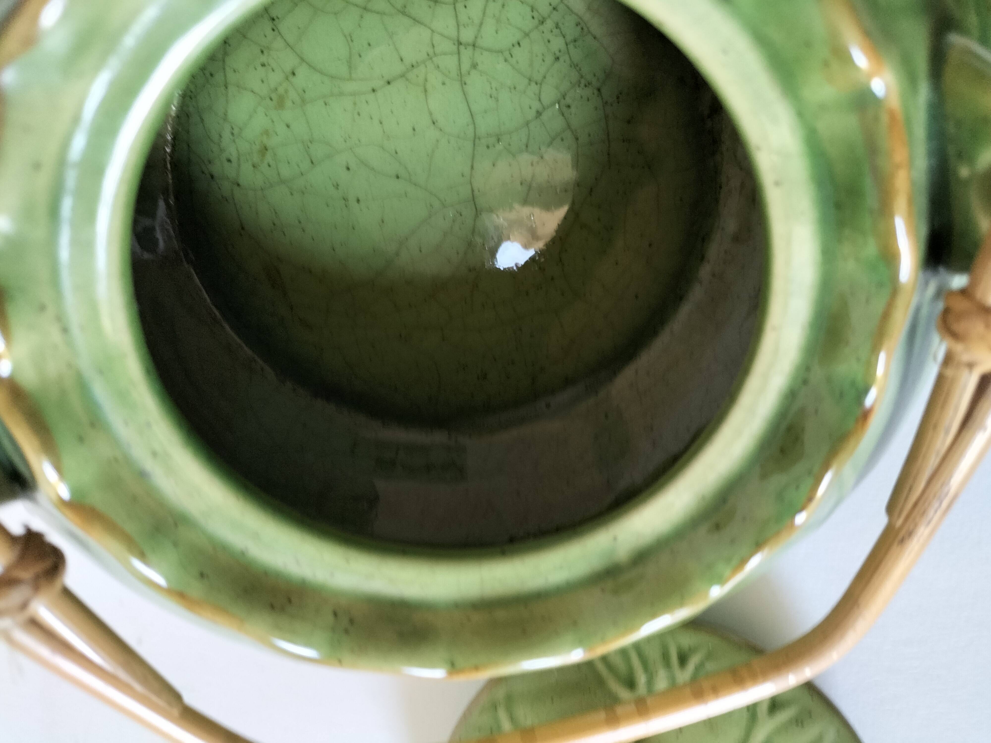 Vintage green teapot with lotus decoration and bamboo handle.