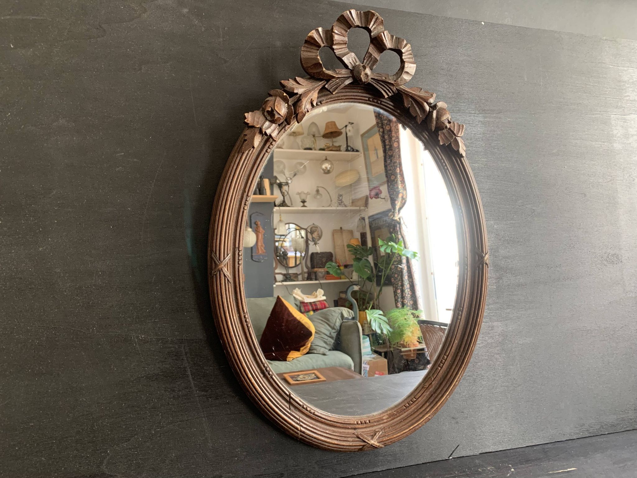 Antique oval mirror in carved wood and Louis XVI style knot