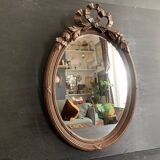 Antique oval mirror in carved wood and Louis XVI style knot