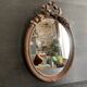 Miroir ovale ancien en bois sculpté et noeud de style Louis XVI