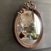 Antique oval mirror in carved wood and Louis XVI style knot