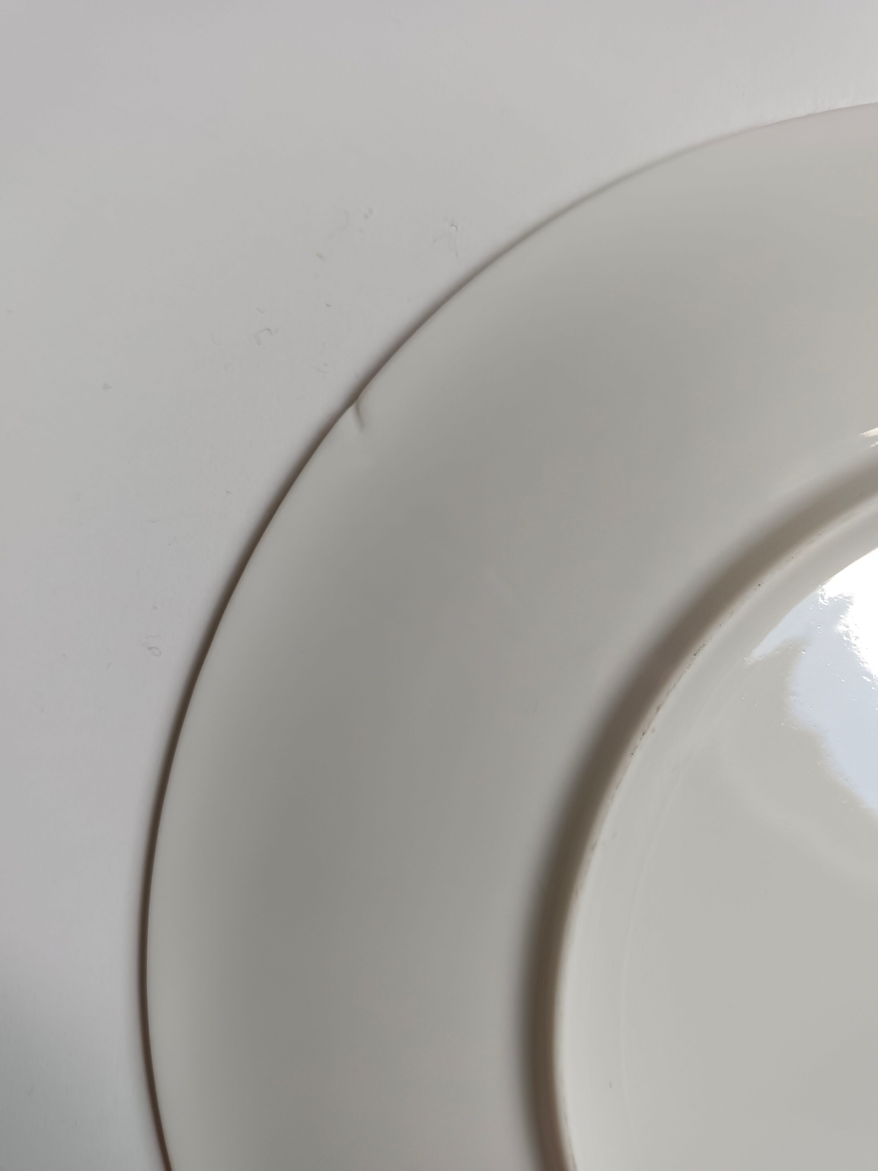 Solitaire tea cup, saucer, and dessert plate in white and gold.