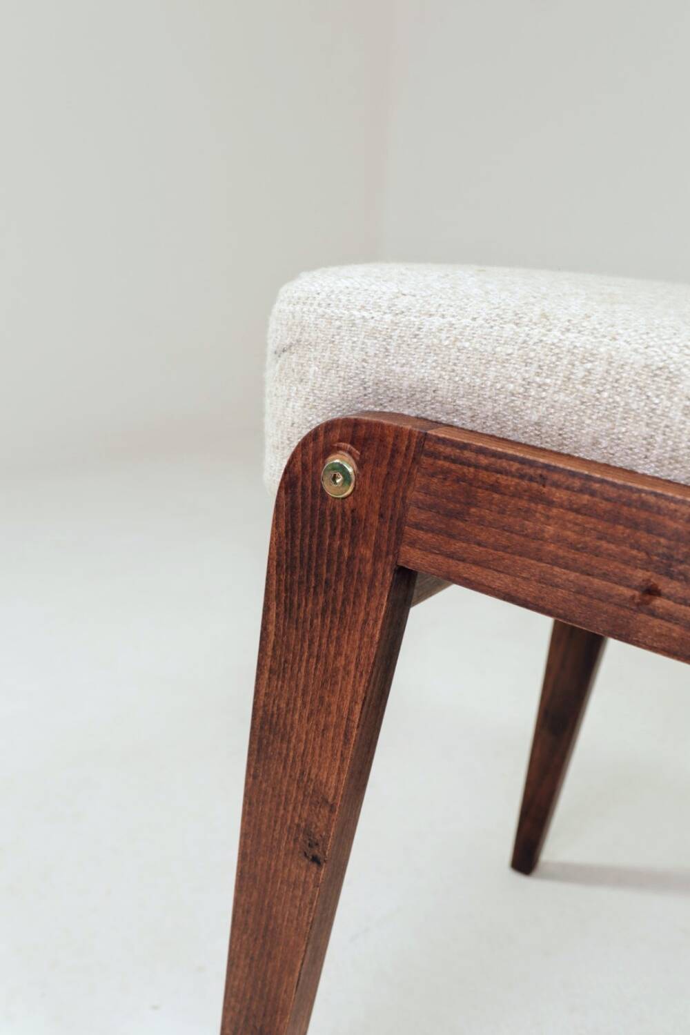 Pair of wooden stools with beige fabric.