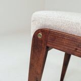 Pair of wooden stools with beige fabric.