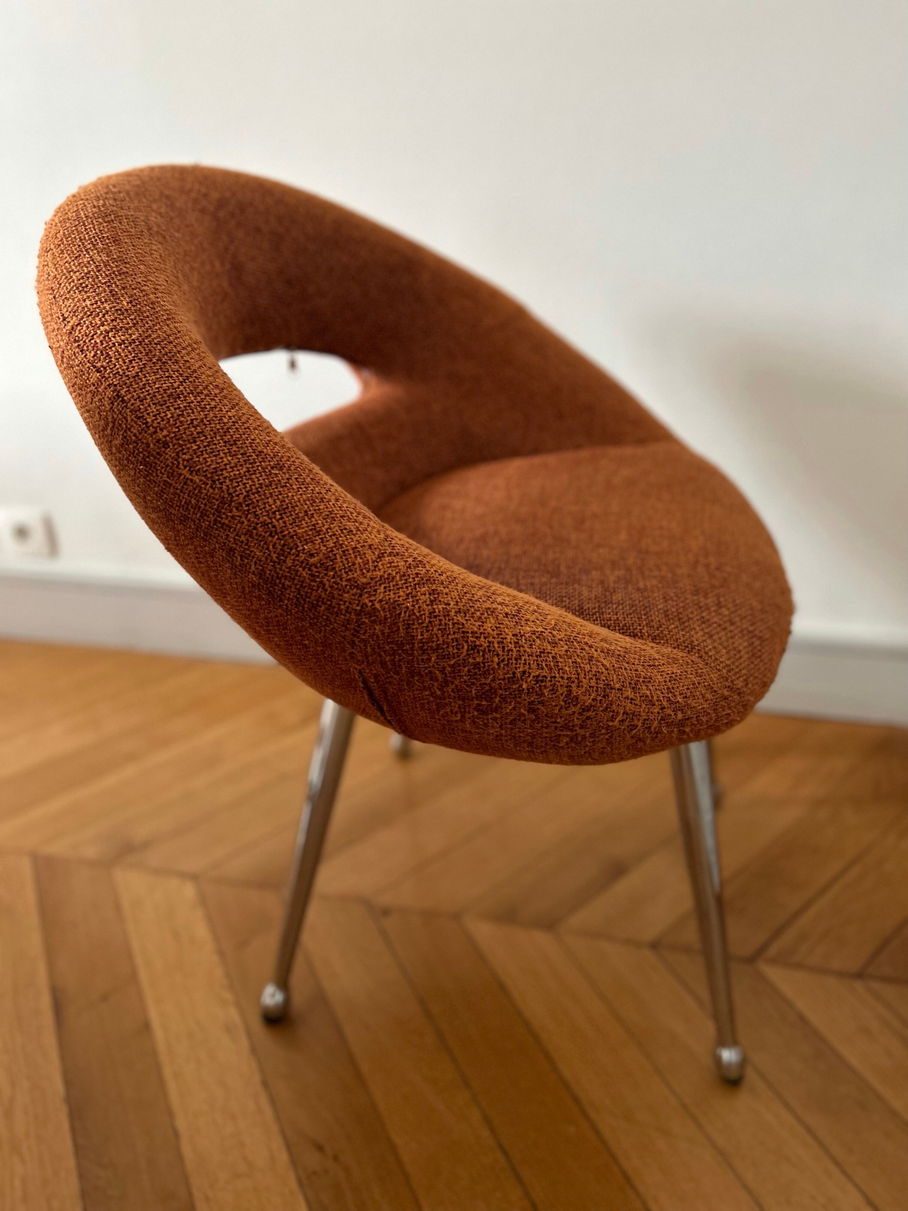 Circular armchair trimmed with orange fabric