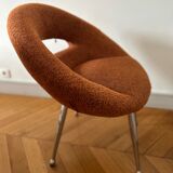 Circular armchair trimmed with orange fabric