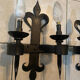 Pair of wrought iron wall lights in fleur-de-lis château style.