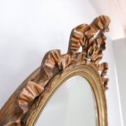 Wear consistent with age and use Wood and gilded plaster "Noeud d'Amour" Oval mirror