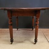 Old round table with folding shutters on casters in solid wood in very good condition