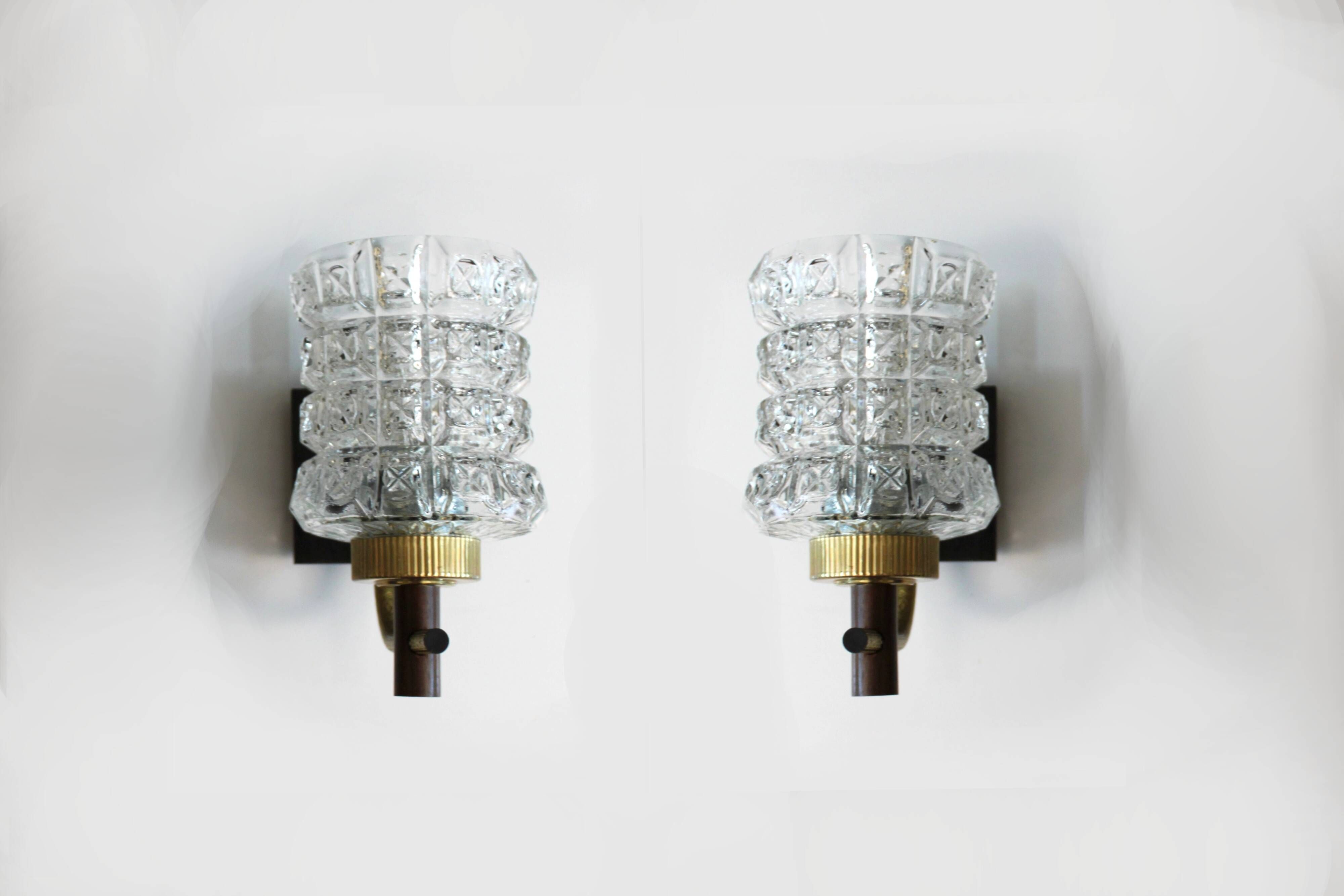 Pair of wall sconces in textured glass, wood, and gold metal, 1970.