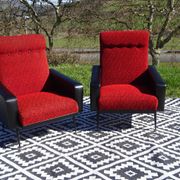 Pair of vintage armchairs in black faux leather and red fabric.