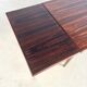 Rosewood dining table with integrated extensions — Denmark, 1960s