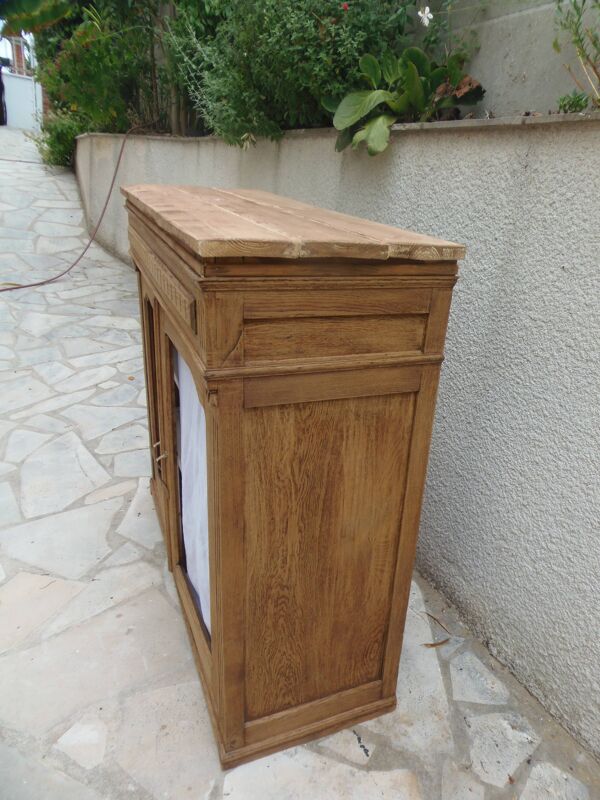 Buffet ancien en bois naturel, portes en tissu et étagères gris perle.