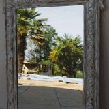 Chic and stylish antique mirror with carved wooden frame in whitewashed