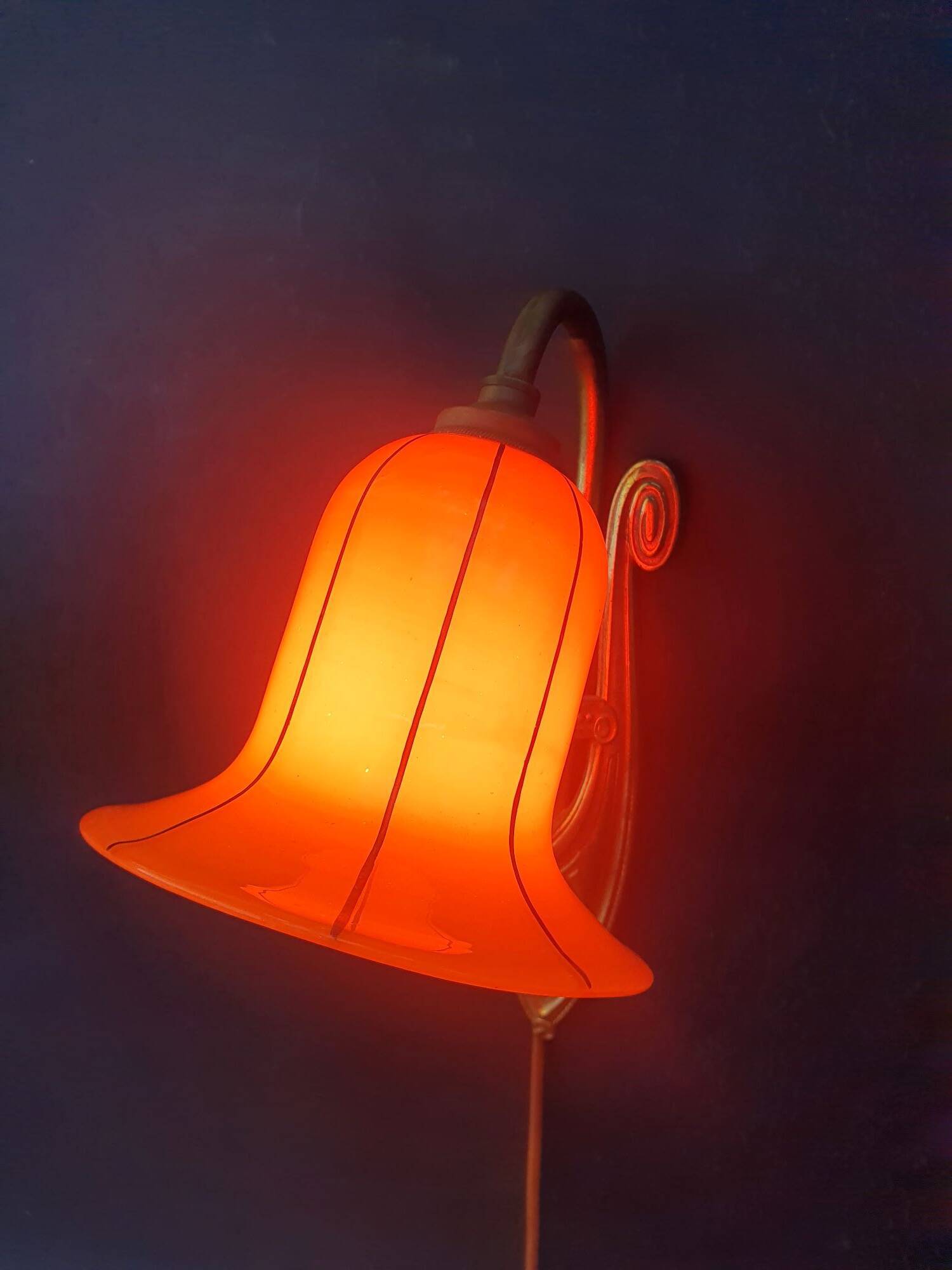 Art Deco wall light in brass with an orange globe.