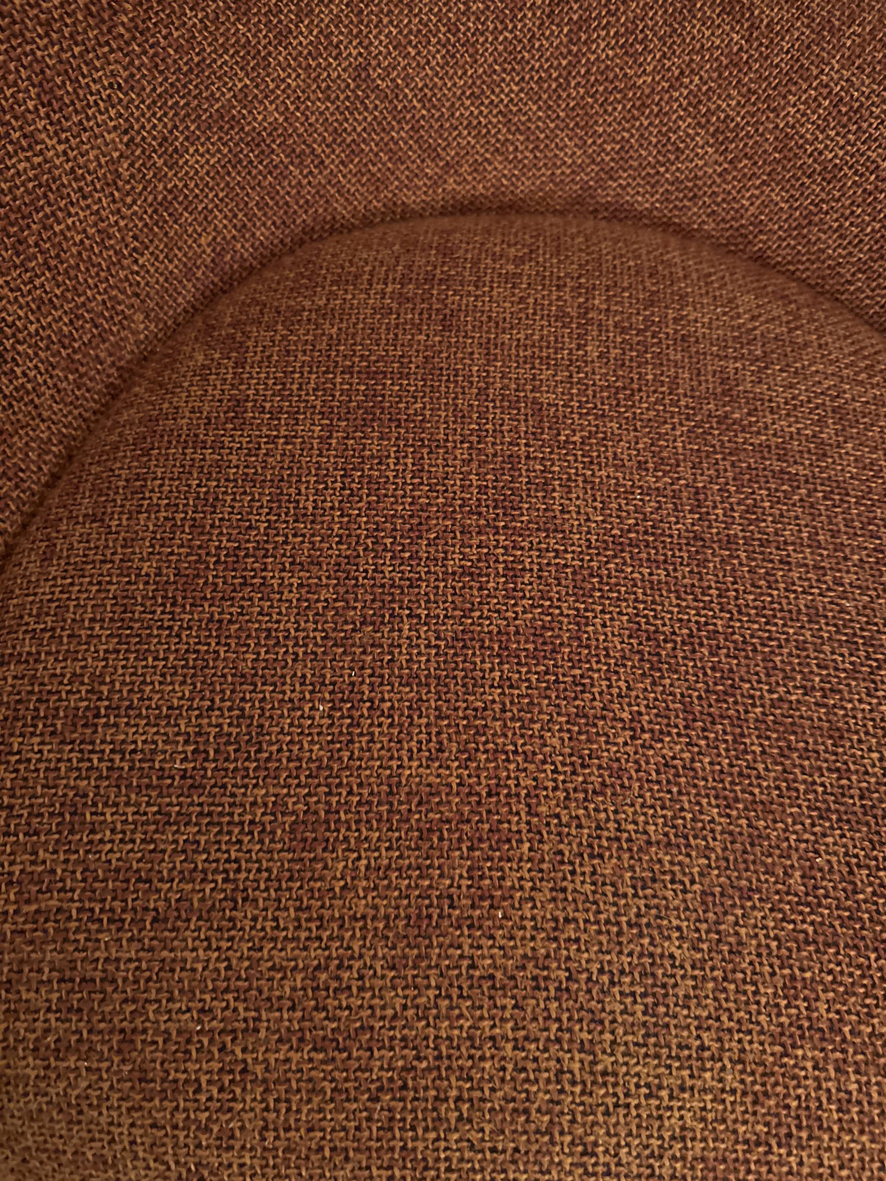 Circular armchair trimmed with orange fabric