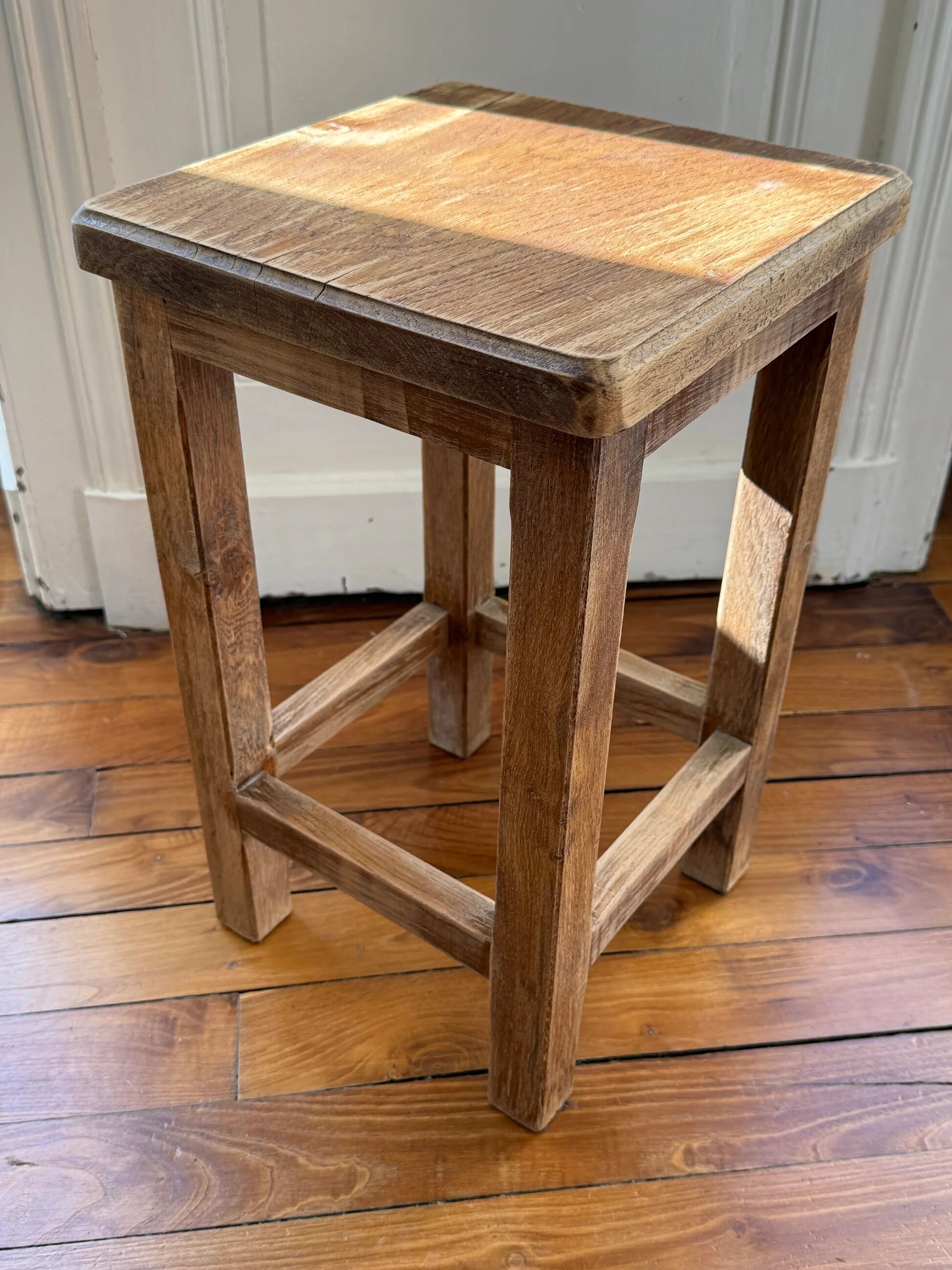 Brutalist stool in raw wood with a weathered effect.