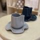 Set of ceramic artisan mugs with blue-grey pop water lily design.
