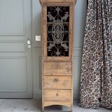 Column storage unit with a sculpted metal door.